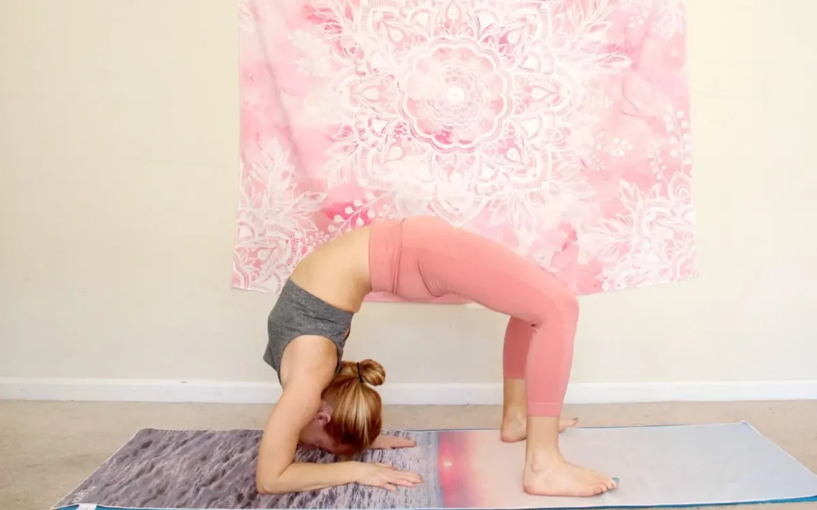 Woman doing a bridge with forearms down as part of a heart opening yoga sequence for advanced yogis