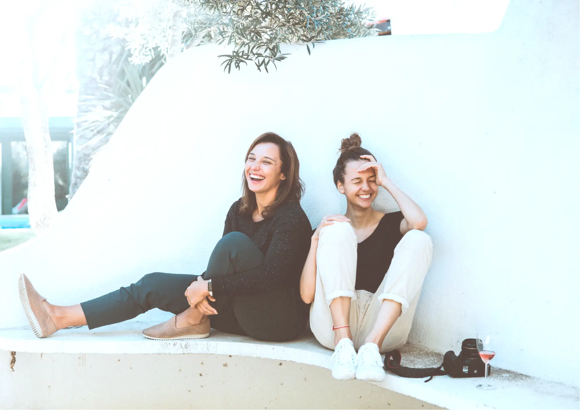 Two women sitting and laughing while practicing gratitude reflection