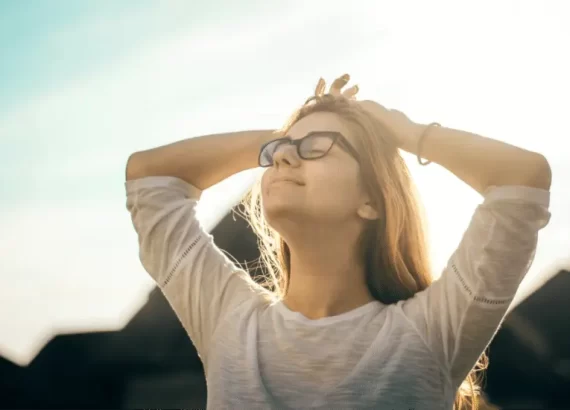 Woman facing up toward the sun, showing that she is happy and at peace