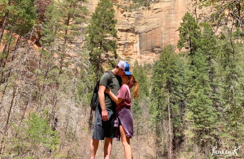 Cover image for the how to be a better partner blog, showing a couple kissing in a beautiful scenic woods
