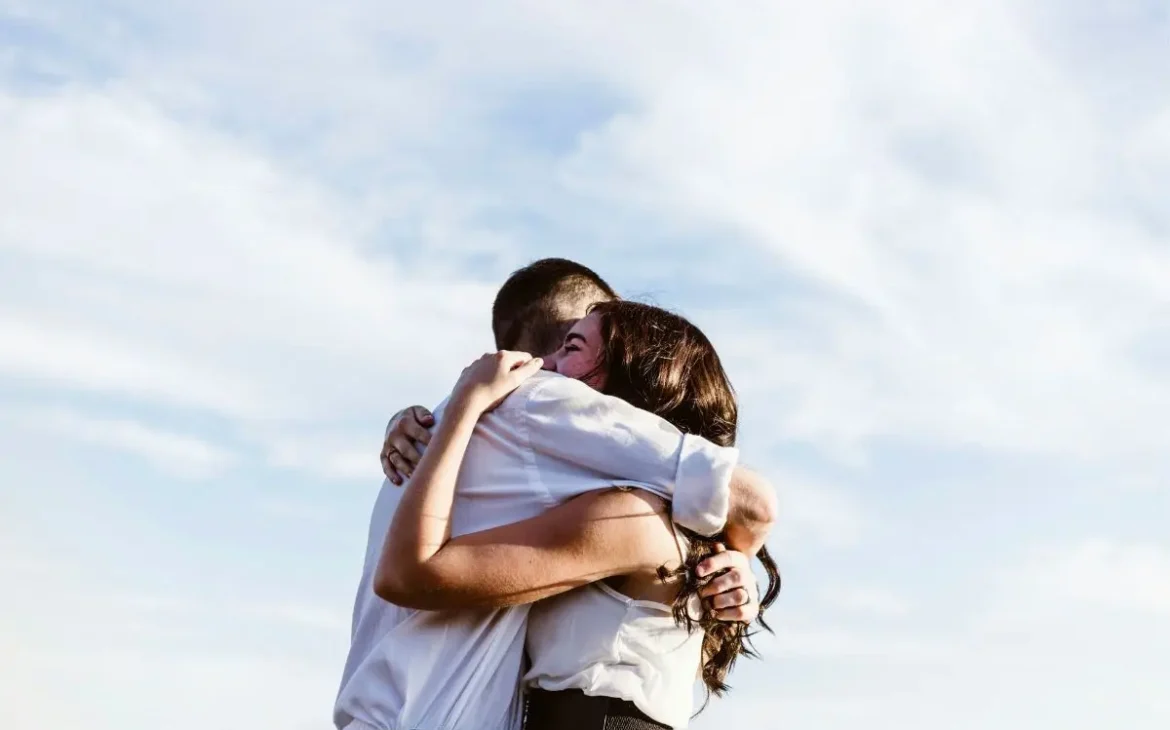 A couple embracing in a hug on a sunny day