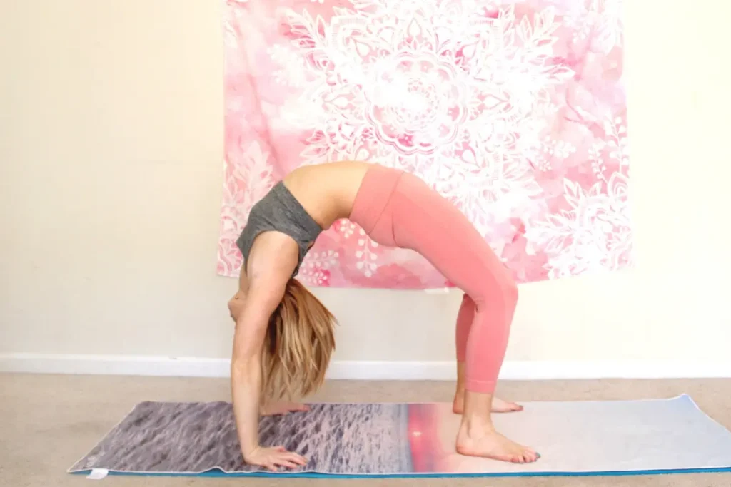 Woman doing wheel pose on a yoga mat