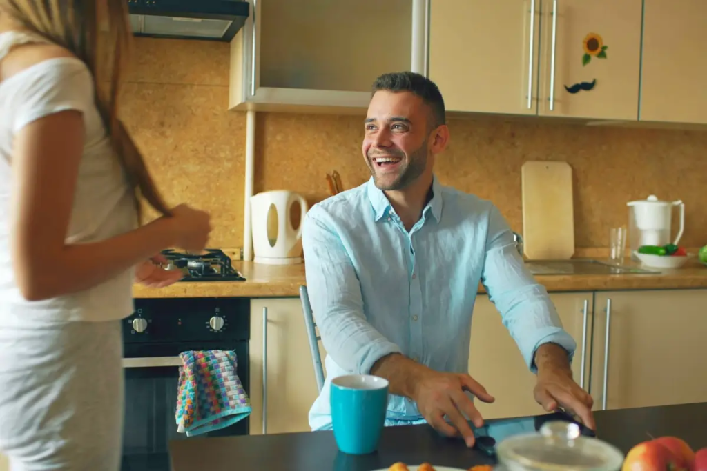 A couple talking in the kitchen, happy and smiling